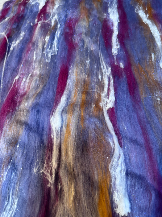 Roving batt with swirling colors of purple, blue, and brown.
